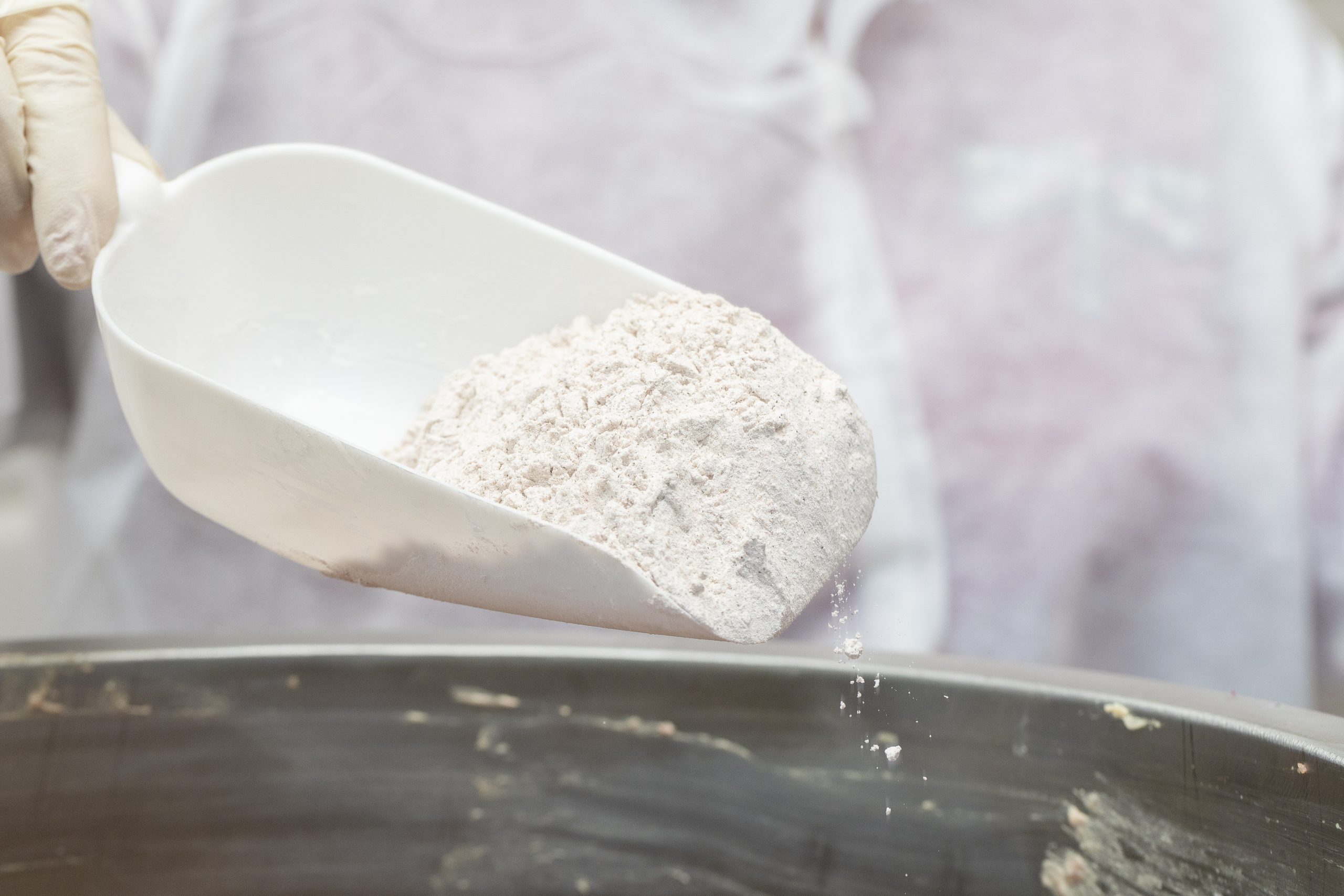 adding flour into frying metallic pan